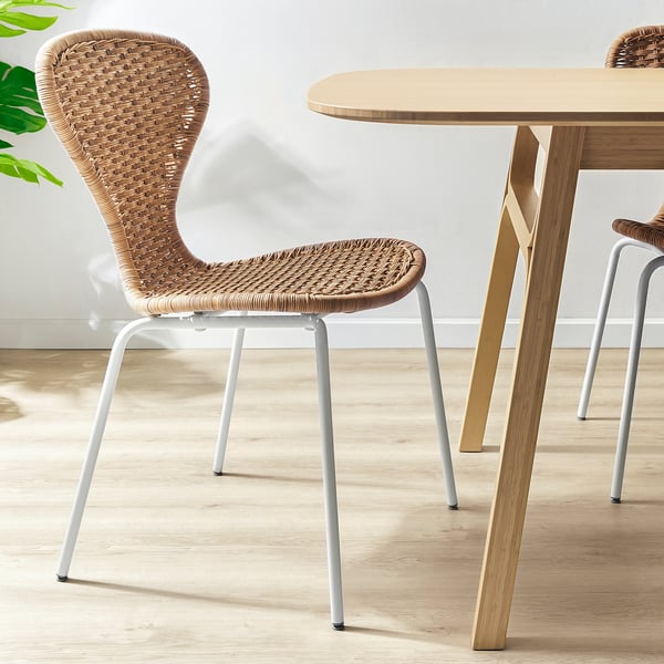 Rattan ÄLVSTA chair with white legs under a matching table, offering comfortable support and a harmonious look.