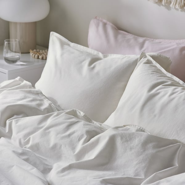 Soft, white bedding set with ruffled edges; includes duvet cover and pillowcases, showcasing high-quality cotton texture.