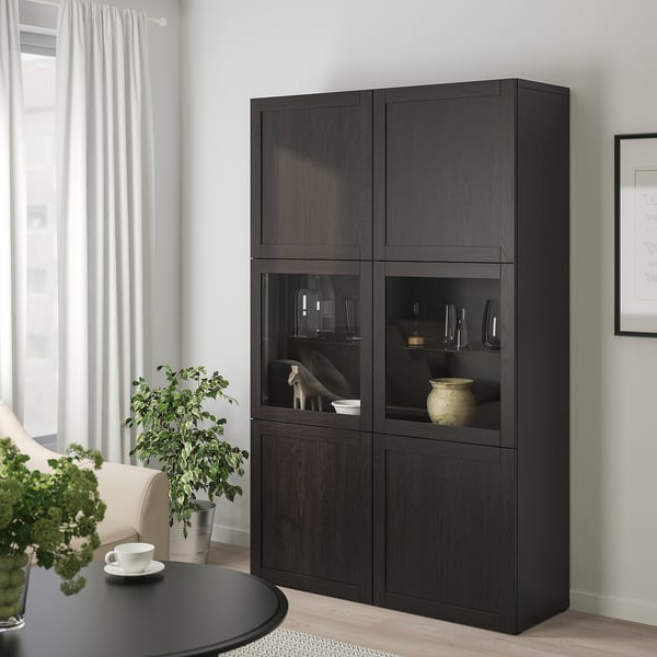 Large BESTÅ storage unit with glass doors, adjustable shelves, near plant & cup.