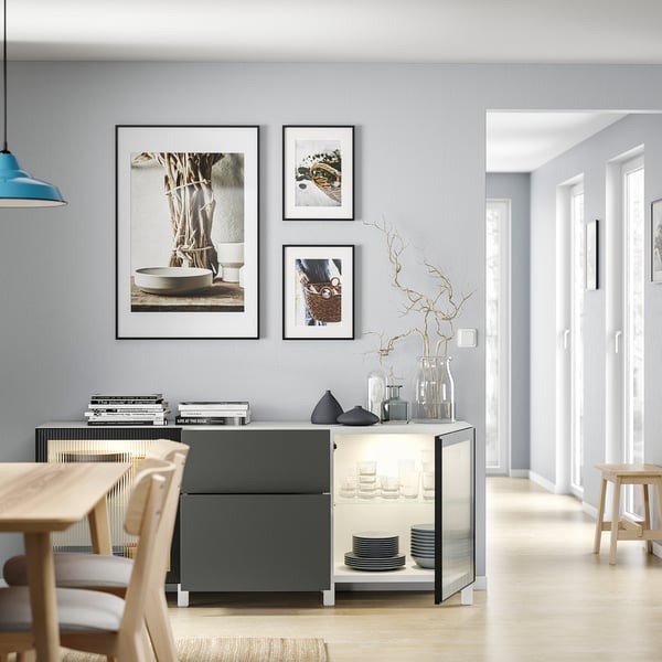 Modern dining with BESTÅ sideboard, dishes, decor, and art.