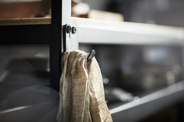 Black BROR hook holds grey towels on metal shelf, simple and sturdy.