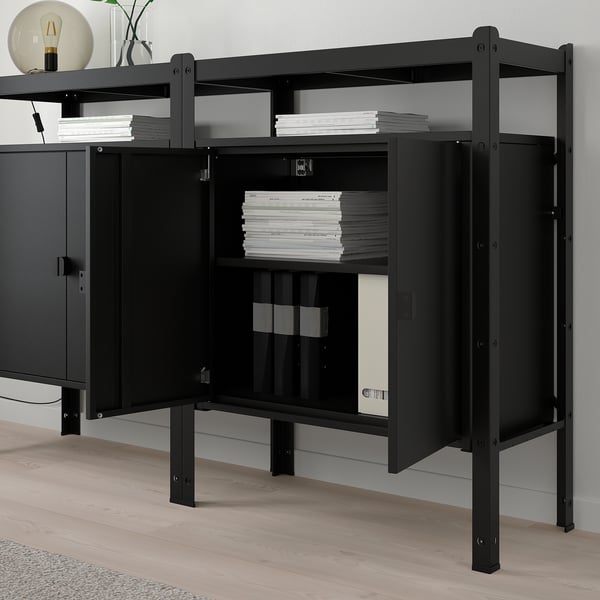 Black metal storage unit holds stacks of paper, combining open and closed cabinets, ideal for organising documents and heavy items.