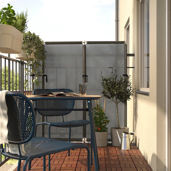 Small blue DUVSKÄR patio set, including a round, wooden-topped table and matching chairs, creating a cosy outdoor seating area on a balcony.