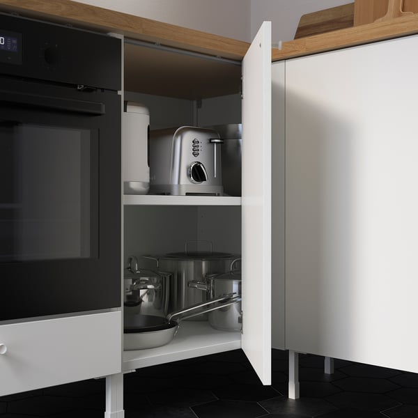 Kitchen cabinet with shelf, storing pots and appliances. Includes single door, visible hinge, and adjustable legs.