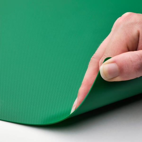 Hand bends green flexible cutting mat.