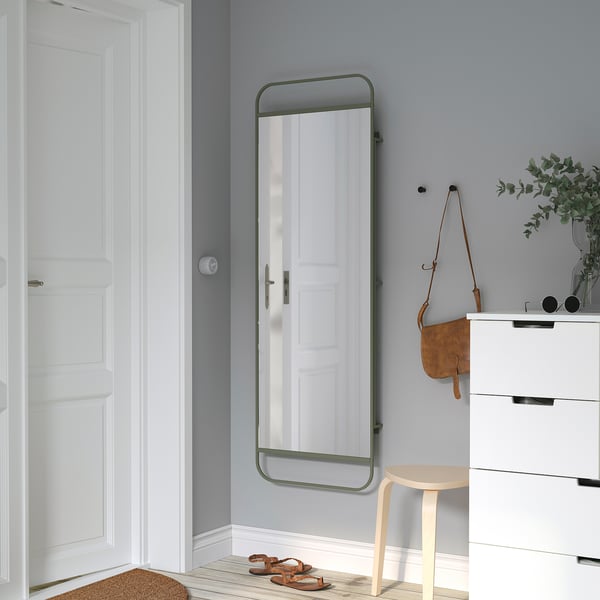 Hallway mirror, stool, dresser, leather bag, sandal, light blue-gray wall.