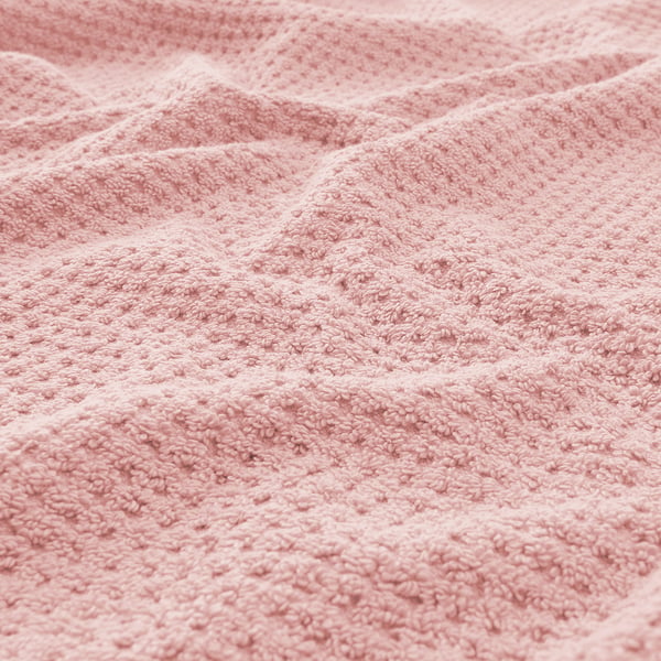 Close-up of soft, textured pink towel. Visible weave pattern conveys durability and absorbency. Fluffy appearance highlights comfort and quality.