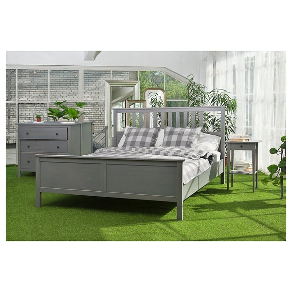 Modern bedroom with HEMNES bed, dresser, and bedside table. Chequered bedspread, bright natural light, plants, sheer curtains.