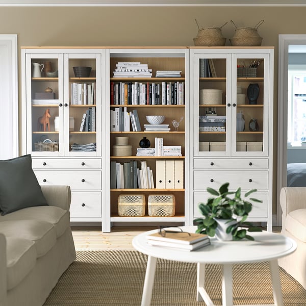 HEMNES bookcases with books & decor, beige couch & green plant.
