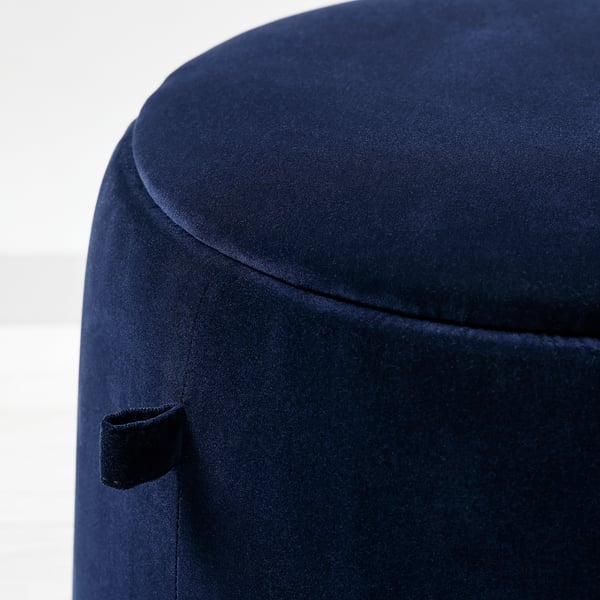 A dark blue upholstered stool with a sleek, curved design and visible seam detailing, appearing well-crafted and stylish.