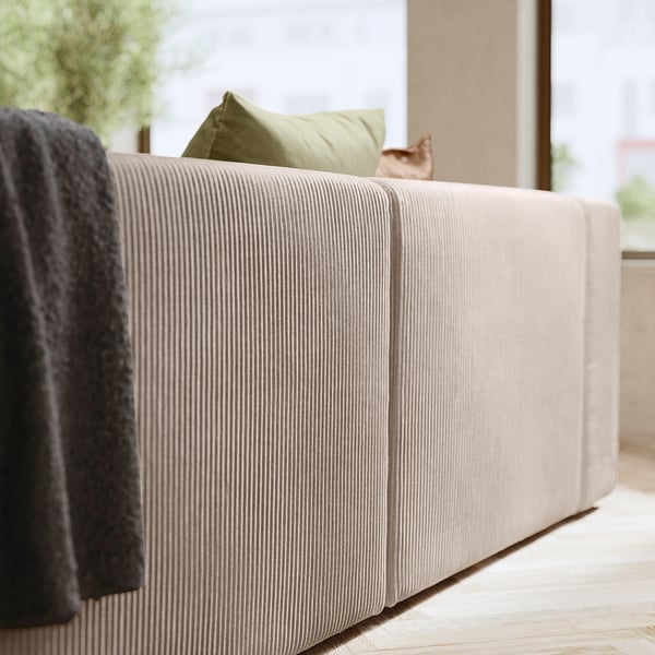 Modern beige sofa with green pillow, cosy & stylish.
