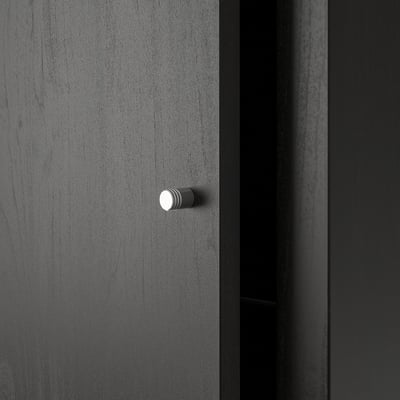 A dark grey KALLAX shelf unit, sleek and modern. Stylish knobs for drawers, set against a smooth, finished surface.