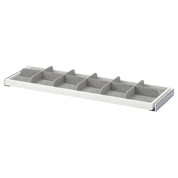 A KOMPLEMENT grey and white drawer divider with multiple compartments for organising small items.