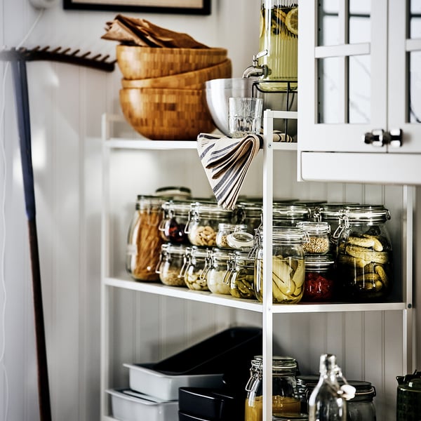 Glass jars neatly organised on shelves, ideal for preserving foods, pickles, and jams, with transparent bodies for visibility.