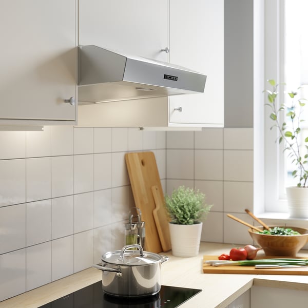 Modern kitchen with stainless hood, white cabinets.