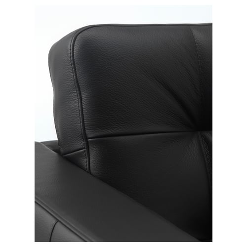 Black leather chair close-up; smooth, strong grain with detailed stitching.