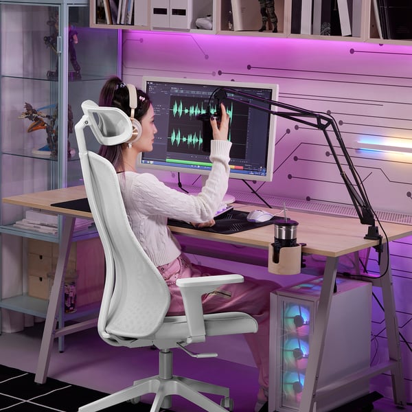 Person using LÅNESPELARE mic arm at cluttered desk, editing audio.