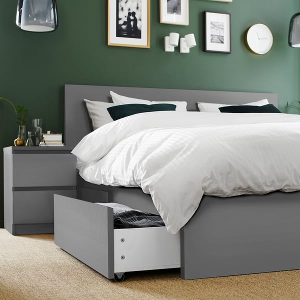Modern bedroom with MALM bed, white bedding, under-bed storage, dark green walls, art, bedside table.