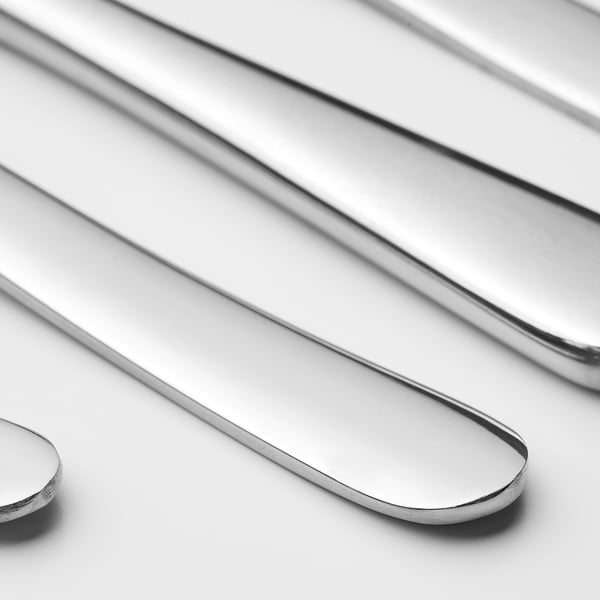 Polished stainless steel cutlery set arranged neatly, showcasing sleek handles and sharp edges, reflecting light for a shiny finish.