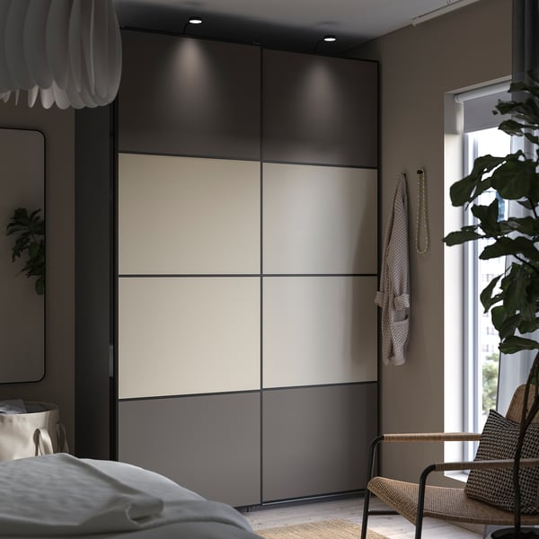 Modern bedroom with sliding wardrobe, featuring double-sided beige and grey panels, sleek design, and minimalist decor.