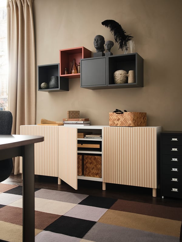 Modern room with MEJARP storage units: light wooden cabinet, black shelves, decorative items, colourful rug.