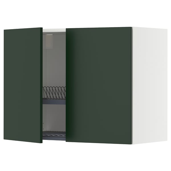 Modern dark green kitchen cabinet with one open door showing an adjustable shelf and a metal dish drainer.
