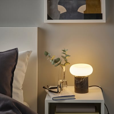 Cosy bedroom with MOLNART lamp, vase, book, and art.