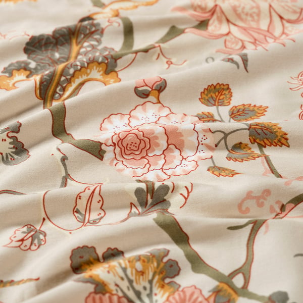 Floral-patterned bedspread in beige with soft, intricate detailing.