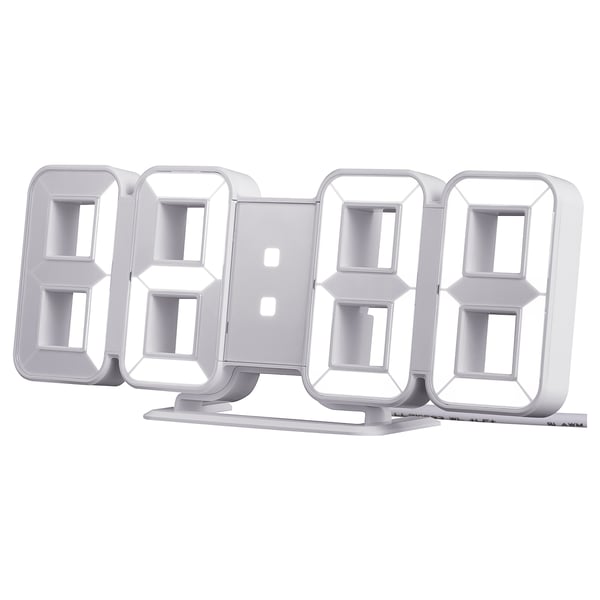 A silver, modern alarm clock named NOLLÅTTA with a clear digital display and adjustable brightness.