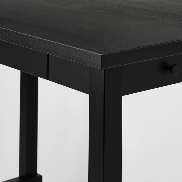 Close-up of robust black wooden table with smooth surface and sturdy metal legs.