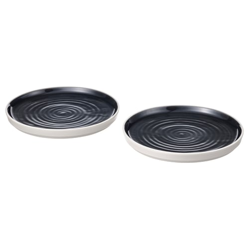 Two black, round, ceramic dishes with white rims and swirling patterns, positioned side by side.
