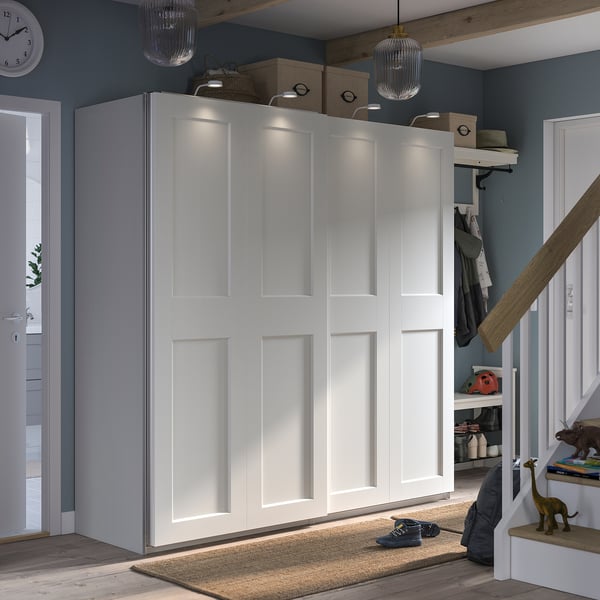 A white PAX wardrobe with sliding doors and built-in lighting. Its a modern, minimalist design ideal for smaller spaces.