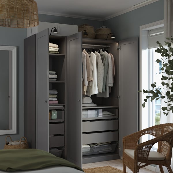 A well-organized bedroom wardrobe with clothes, towels, and drawers. Lighting and shelves are visible inside.