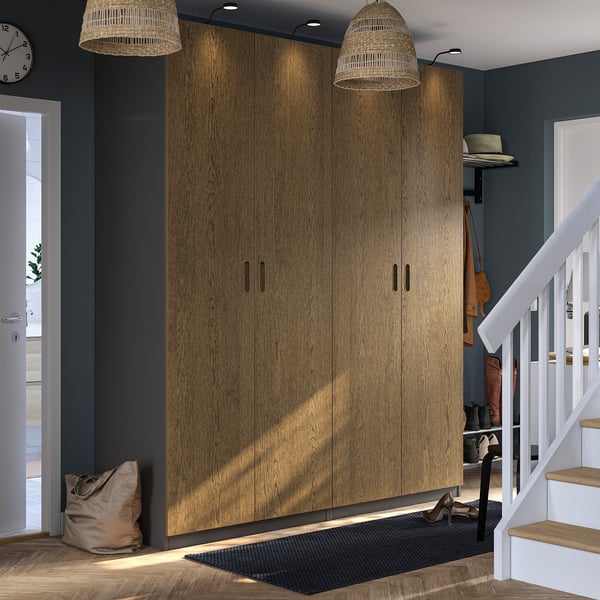 Modern entryway with oak PAX wardrobe, pendant lamps, staircase, coat stand, jute mat, and clock.