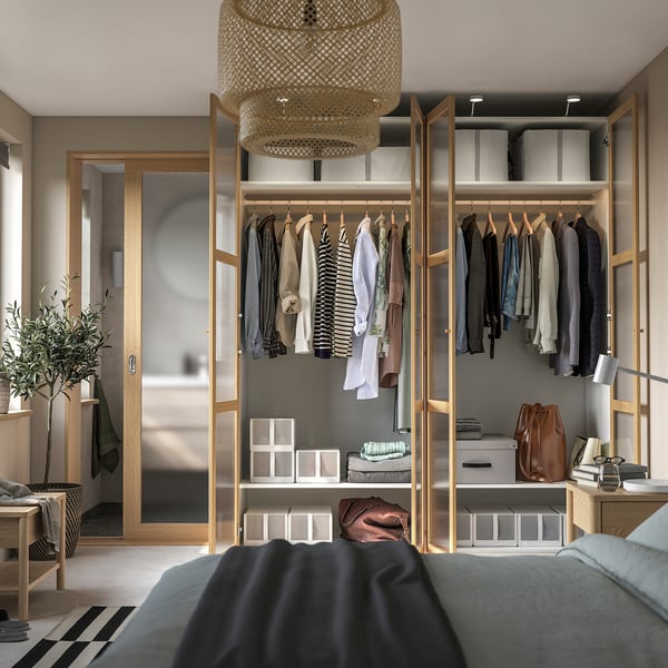 Modern wardrobe with hanging clothes, shelves, and a stylish pendant light. Part of an organised bedroom suite.