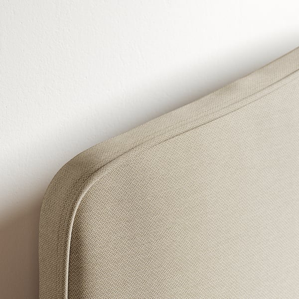 Close-up of a well-crafted, upholstered bed frame corner, showcasing smooth, durable fabric and precise stitching.