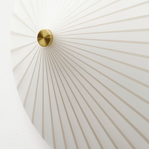 This modern wall sconce a stylish, gold centre point emitting numerous thin, white light rays, creating a sophisticated and elegant ambiance.