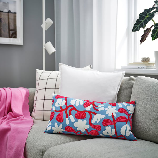 Blue red-floral sandmot cushion on couch with pillows.