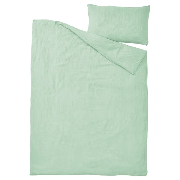 A light green SCHERSMIN duvet cover and pillowcase in soft, airy muslin fabric made from 100% organic cotton.