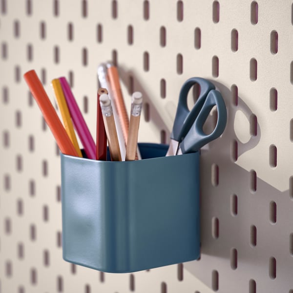 Blue SKÅDIS organiser on pegboard holds pens and scissors, keeping items handy and organised.