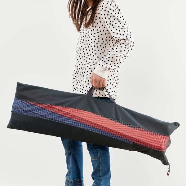A person holding an obstacle course bag with colourful hurdles and cones.
