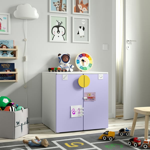Kids room with multicoloured clock on purple cabinet, toy vehicles, and wall frames.