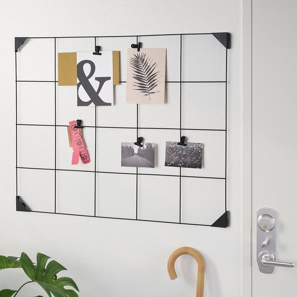 Wall-mounted memo board with clips holding various papers, photos, and notes; ideal for organising and displaying important information.