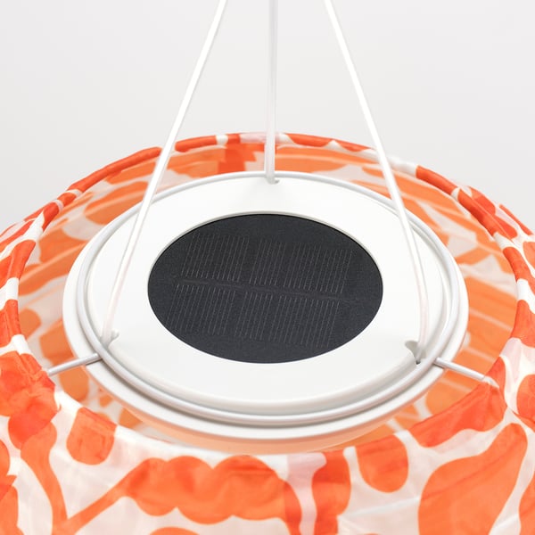 A solar-powered pendant lamp with orange patterned shade and a black solar panel, showcasing quality and eco-friendly design.