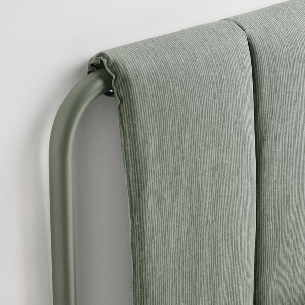 Close-up of modern bed frame: sleek upholstery, sturdy metal bar, clean lines.