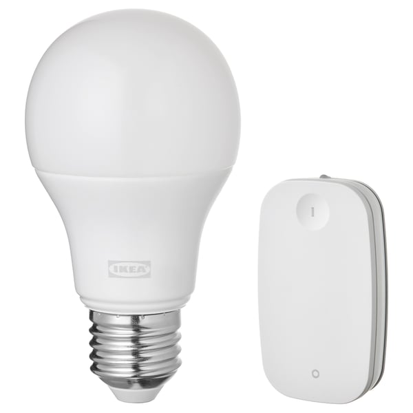 A white ikea TRÅDFRI smart light bulb and remote control. The bulb is spherical and the remote is rectangular, both are white.