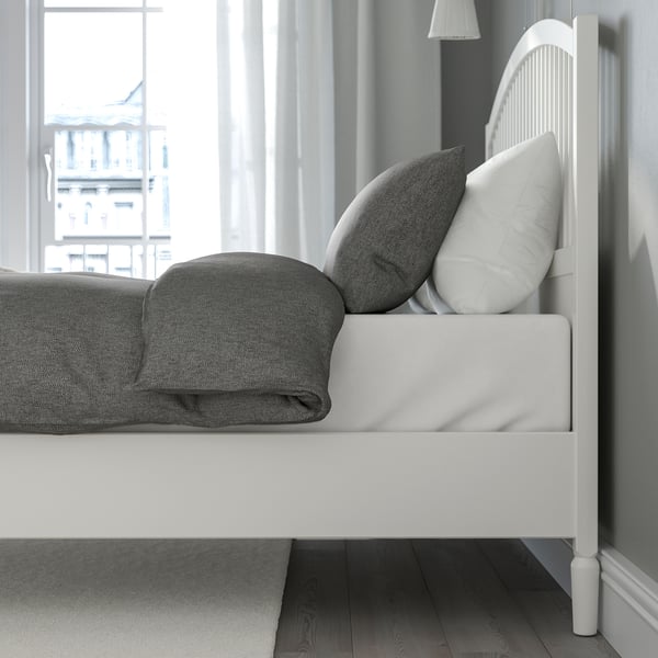 Minimalist bed frame with adjustable sides, high headboard, and wooden spindle details, shown with grey linens.