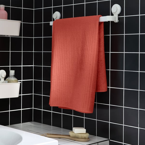 Orange VÅGSJÖN towel on black bathroom wall rack.