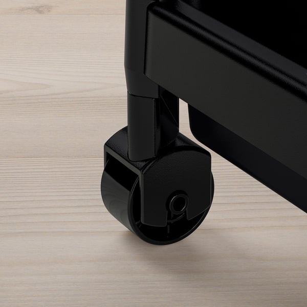 Black caster wheel on a sturdy, clear plastic trolley base on wooden floor.