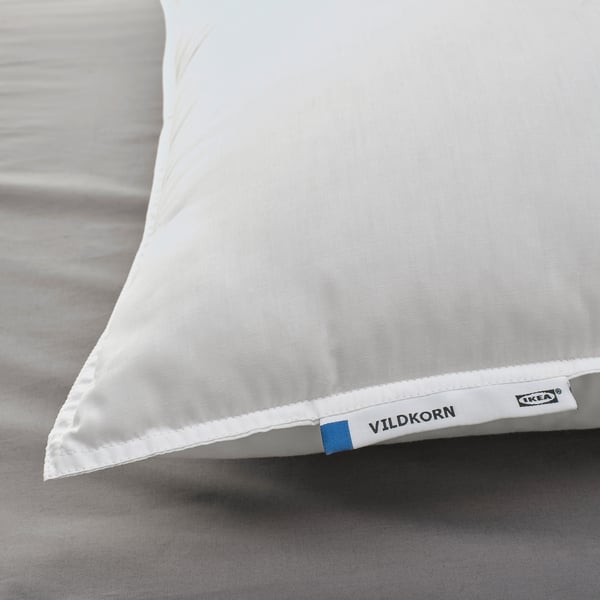 Soft, supportive pillow rests on bed, marked VILDKORN by IKEA, showcasing quality feel and design.